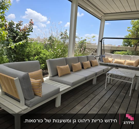כריות פסים צהובות על ספות אפורות במרפסת